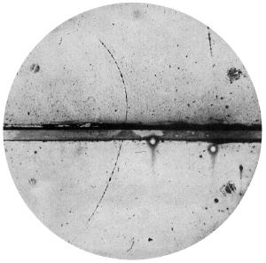 Photograph of a cloud chamber showing the first discovered positron.