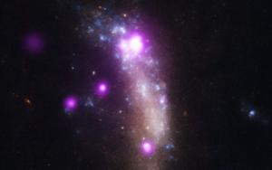 Composite image of UGC 5189A shows X-ray data from Chandra in purple and optical data from Hubble Space Telescope in red, green and blue.