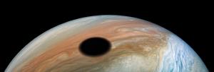 The shadow of Io against Jupiter's cloudy surface.