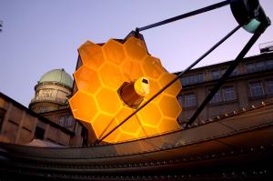 A photograph of a full-scale model of the James Webb Telescope. The seven hexagonal mirrors of JWST are clearly seen.