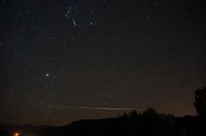 A meteor trail seen under the constellation Orion.