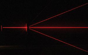 Red laser light passing through a diffraction grating.