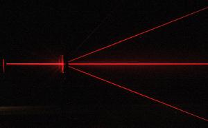 Red laser light passing through a diffraction grating.