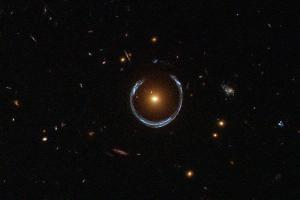 A distant galaxy (blue) is gravitationally lensed by a closer galaxy (red).