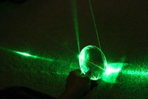 A green laser reflecting through glass.