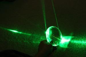 A green laser reflecting through glass.